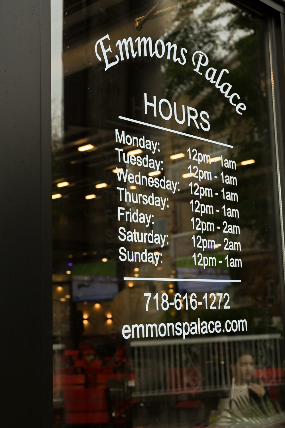 Emmons Palace storefront window with hours